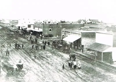 A wide dirt street in Byers lined with buildings on both sides.