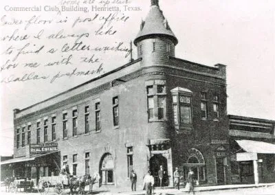 An ornate two-story brick corner building with a rounded tower and tall arched windows.