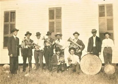 Band members in uniform with brass instruments and a bass drum.