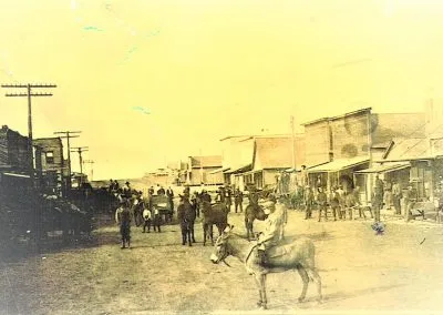 A dirt main street lined with frame storefronts.