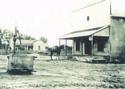 A small frame post office with its well outside.