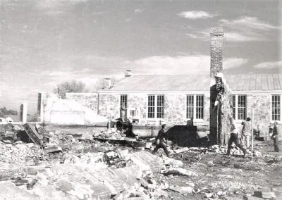 The roofless shell of a gymnasium, its walls still standing after a fire.