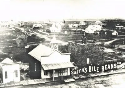 A row of wooden false-front buildings along a dirt street.
